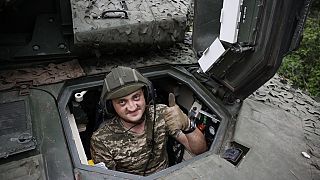 A Ukrainian soldier gives the thumb-up sign on a Swedish CV90 infantry fighting vehicle at his positions near Bakhmut.