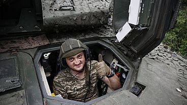 A Ukrainian soldier gives the thumb-up sign on a Swedish CV90 infantry fighting vehicle at his positions near Bakhmut.