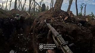 Soldados ucranianos disparam a partir de trincheiras contra brigada russa, perto de Bakhmut.