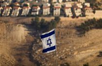 Eine israelische Flagge mit der israelischen Siedlung von Maaleh Adumim im Hintergrund