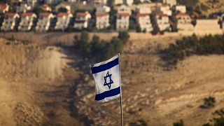 Eine israelische Flagge mit der israelischen Siedlung von Maaleh Adumim im Hintergrund