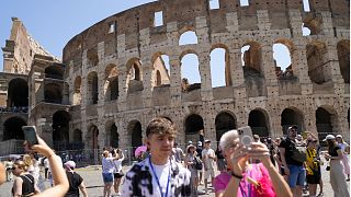 Visitors take photos of the Ancient Colosseum, in Rome, Tuesday, June 27, 2023.