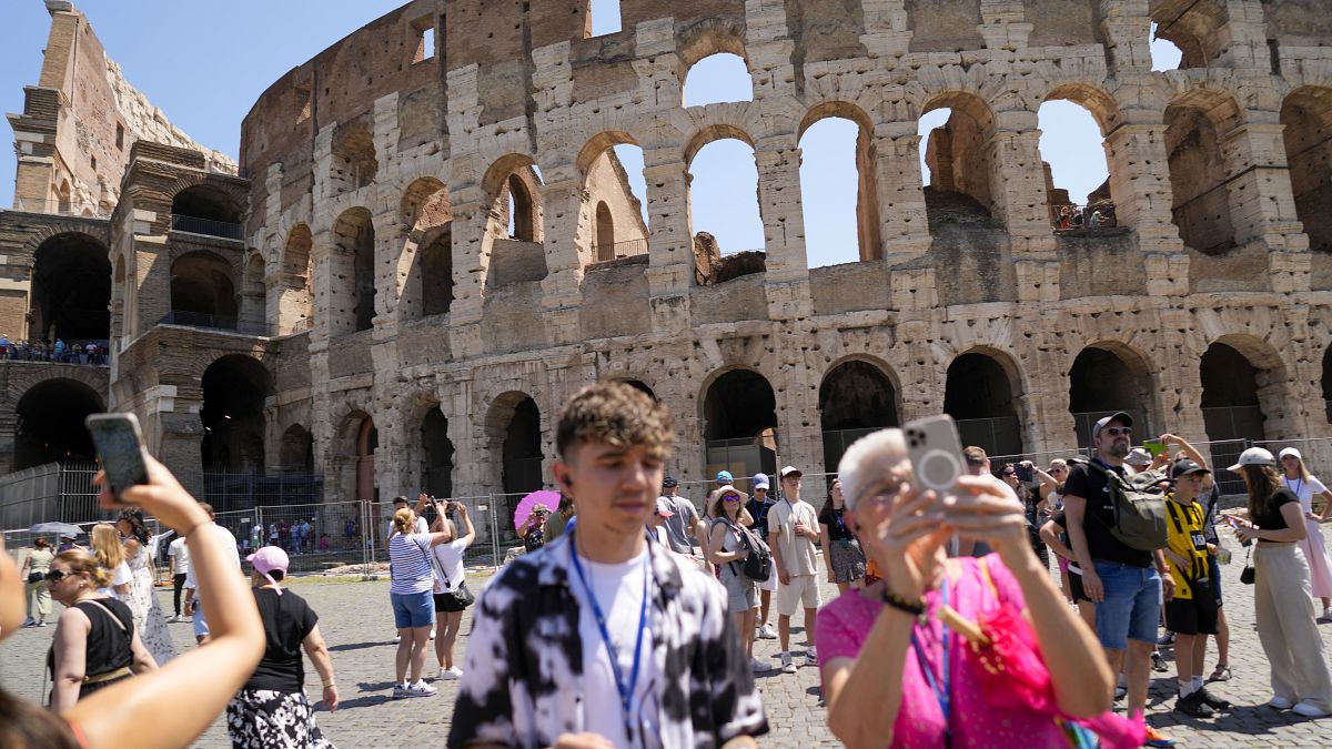 Des visiteurs prennent des photos de l'ancien Colisée à Rome.