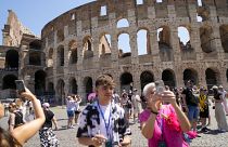 Des visiteurs prennent des photos de l'ancien Colisée à Rome.