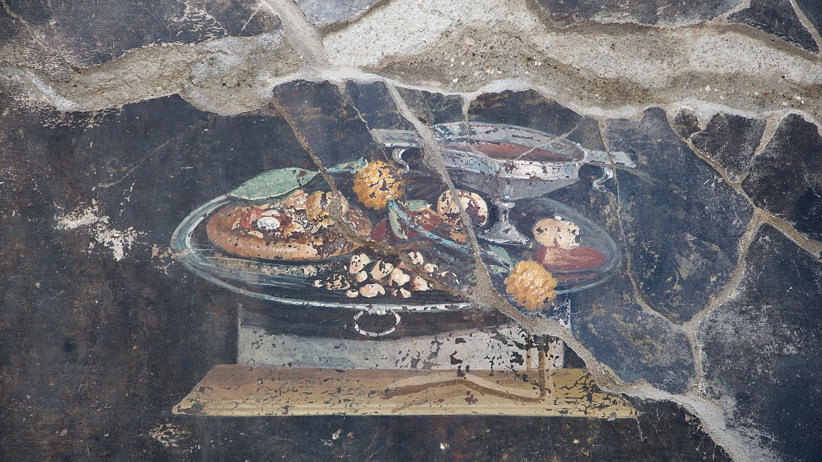 Archaeologists carefully excavate the wall where the ‘pizza’ fresco was found on the northeastern end of the archaeological park