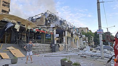 People walk past destroyed restaurant in Kramatorsk, eastern Ukraine.