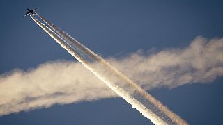 Ein Flugzeug kreuzt die Kondensstreifen eines anderen Flugzeugs über Frankfurt. Die Erforschung von Technologien zur Bekämpfung des Klimawandels bleibt umstritten