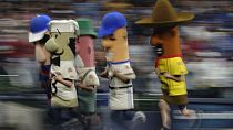 The Racing Sausages run during the sixth inning of a baseball game, 2023.