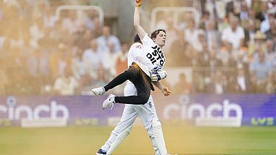 England's Johnny Bairstow carries a Just Stop Oil protester off the pitch during day one of the second Ashes Test cricket match at Lord's Cricket Ground, London, England.