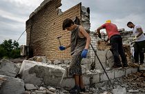 Danyk Rak, 12, clears rubbish on the second floor of Zhanna and Serhiy Dynaeva's house which was destroyed by Russian bombardment in Novoselivka village Aug. 13, 2022