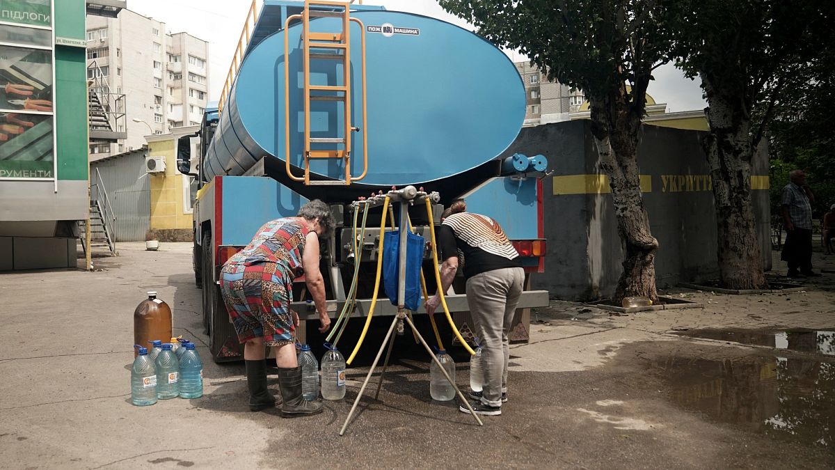 Residentes enchem garrafas com água potável de um tanque em Kherson
