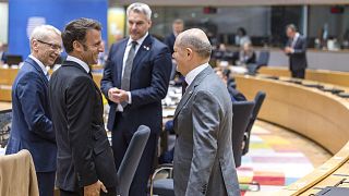 France's President Emmanuel Macron, second left, speaks with Germany's Chancellor Olaf Scholz, right, during a round table meeting at an EU summit in Brussels, June 29, 2023. 