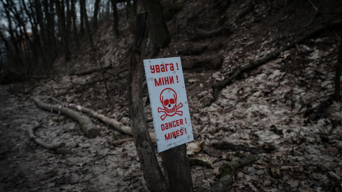 A billboard indicates the presence of landmines at the position of a Ukrainian volunteer unit in a suburb of Kyiv on February 28, 2023. 