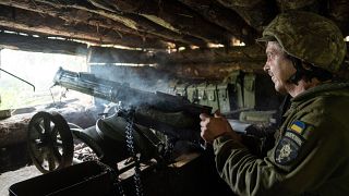 A Ukrainian serviceman of the 28th brigade shoots a Maxim gun towards Russian positions at the frontline in Donetsk region.