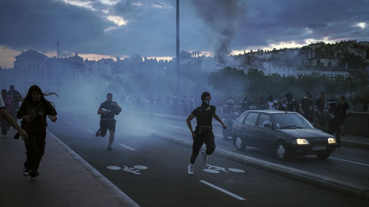 People run away during clashes with police in the center of Lyon, central France, Friday, June 30, 2023.