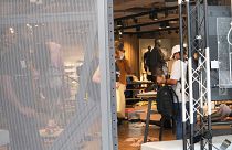 محققو الشرطة يعملون في متجر رياضي متضرر ومنهوب بعد ليلة ثالثة من الاضطرابات في باريس. 2023/06/30