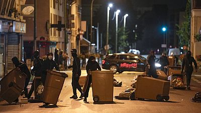 Protesters block a street with garbage cans in Colombes, outside Paris, France, Saturday, July 1, 2023.