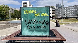 Graffiti reads "Riots for Nahel, Explosion for Darmanin," referring to French Interior Minister Gerald Darmanin, on an urban furniture on July 2 in the Paris suburb Nanterre.