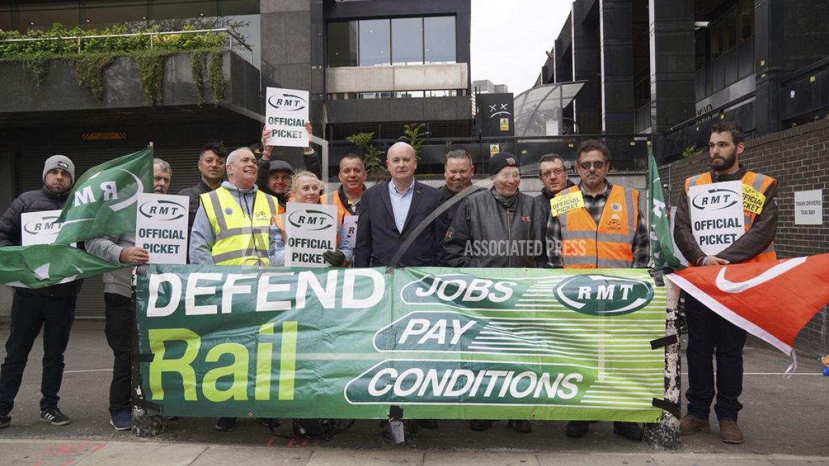 Rail, Maritime and Transport union general secretary Mick Lynch, center, joins members of his union on the picket line outside Euston train station, London.