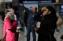Reisende schauen auf die Anzeigetafel der Züge in der Londoner Waterloo Station