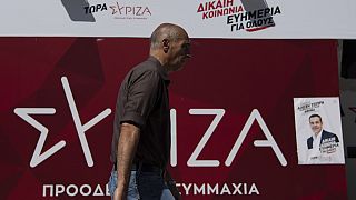 Πολίτης περνάει μπροστά από προεκλογικό περίπτερο του ΣΥΡΙΖΑ στην Αθήνα
