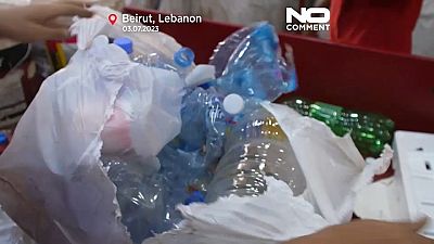Un employé de Lebanon Waste Management (LWM), récupère des déchets à un centre de tri à Beyrouth, le 22 juin 2023