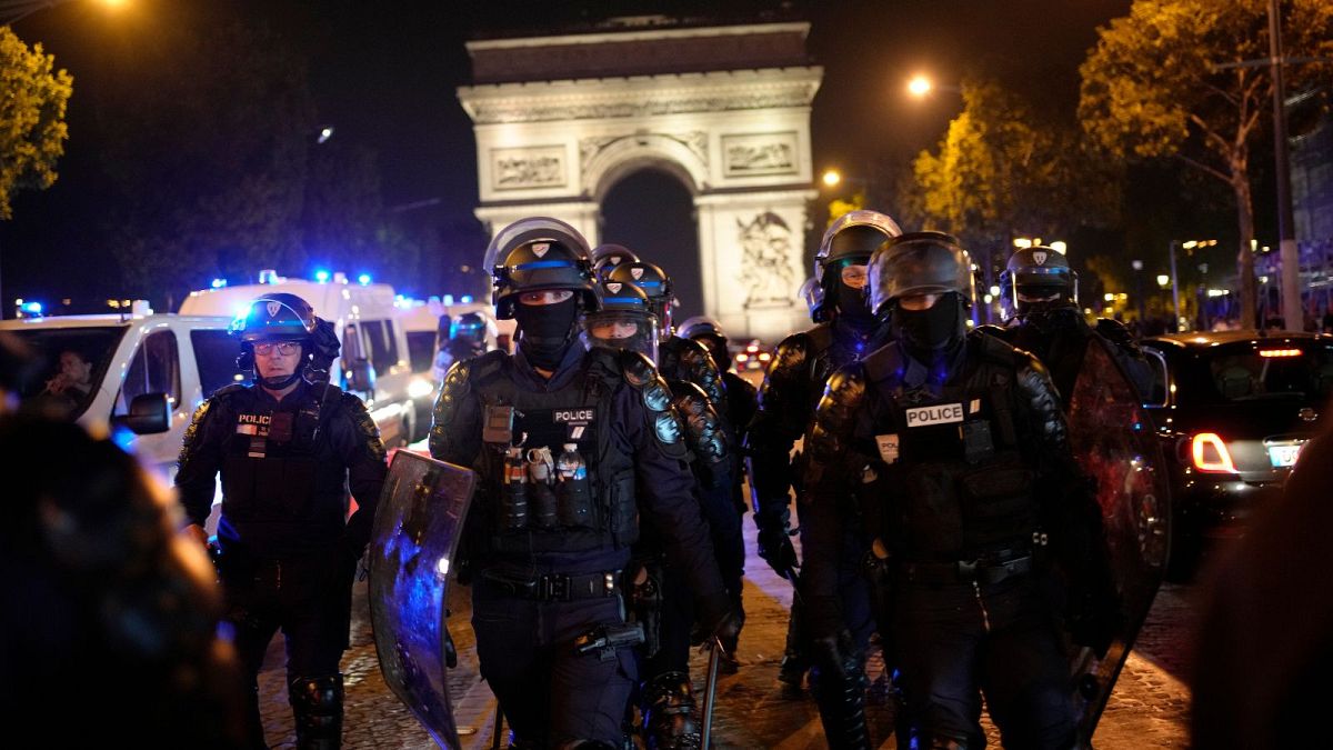 Agenti di polizia di pattuglia davanti all'Arco di Trionfo sugli Champs Elysees a Parigi, 1 luglio 2023.