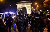 Police officers patrol in front of the Arc de Triomphe on the Champs Elysees in Paris, 1 July 2023.