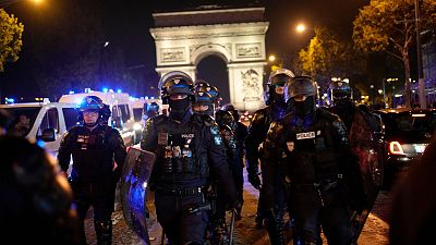 Police officers patrol in front of the Arc de Triomphe on the Champs Elysees in Paris, 1 July 2023.