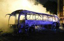 Firefighters use a water hose on a burnt bus in Nanterre, outside Paris, France, July 1, 2023.