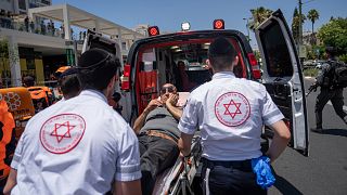 Des ambulanciers israéliens évacuent un homme blessé après un attentat à la voiture-bélier à Tel Aviv, Israël, mardi 4 juillet 2023.
