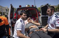 Mentősök szállítják el a gázolásos támadás egyik sérültjét Tel Avivban