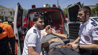 Mentősök szállítják el a gázolásos támadás egyik sérültjét Tel Avivban