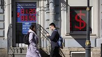 People walk past an exchange office screen showing the currency exchange rates of U.S. Dollar to Russian Rubles in St. Petersburg, Russia, Friday, April 7, 2023. People walk past an exchange office screen showing the currency exchange rates of U.S. Dollar to Russian Rubles in St. Petersburg, Russia, Friday, April 7, 2023.