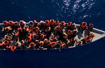 Migranten aus Eritrea, Libyen und dem Sudan segeln in einem Holzboot, bevor sie von Helfern der spanischen NRO Open Arms unterstützt werden