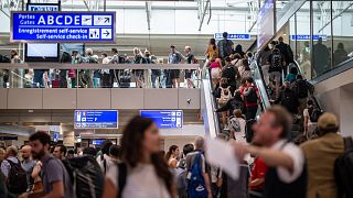 Travellers queue inside Geneva International Airport in Geneva during a strike action by airport workers.