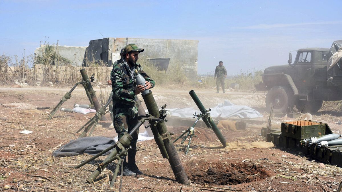 يستعد جنود من الجيش السوري لإطلاق قذيفة هاون باتجاه المسلحين في قرية كفر نبودة بريف محافظة حماة، 11 أيار 2019.