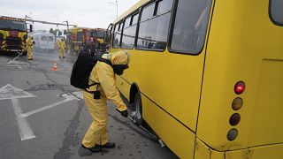 Egy sugárvédelmi ruhát viselő ukrán katasztrófavédelmi dolgozó ellenőrzi a busz sugárzási szintjét az ukrajnai Zaporizzsjában 2023. június 29-én