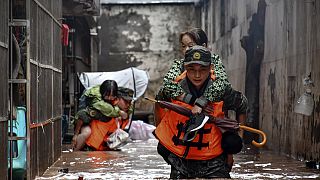 Mέλη της Κινεζικής Λαϊκής Ένοπλης Αστυνομίας εκκενώνουν τους παγιδευμένους από τις πλημμύρες κατοίκους στην περιοχή Wanzhou, στο δήμο Chongqing της νοτιοδυτικής Κίνας
