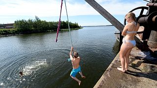 Youths jump into the sea on a hot summer's day, in Vaasa, Finland, July 19, 2018.