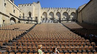People stand in the "Cour d'honneur" of the Popes' Palace (Palais des papes) stage on the first day of this year edition of the Avignon theatre festival in Avignon in 2021