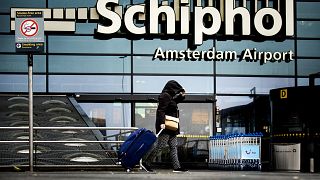 A women pulls a suitcase in high winds outside Schiphol airport, Amsterdam. 