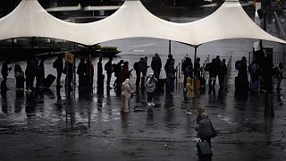 Amsterdam'daki Schiphol Havaalanı'nda şiddetli fırtınanın neden olduğu yağmurdan korunmaya çalışan vatandaşlar