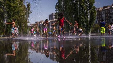 Gyerekek játszanak kánikula idején egy madridi parkban