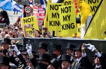 Anti-monarchy protesters hold placards near St Giles' Cathedral in Edinburgh as Charles III arrives for a coronation celebration