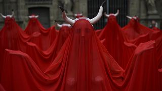 Personas con el cuerpo cubierto con el color rojo de San Fermín protestan contra la crueldad animal antes del comienzo de las fiestas de San Fermín. Pamplona, España.