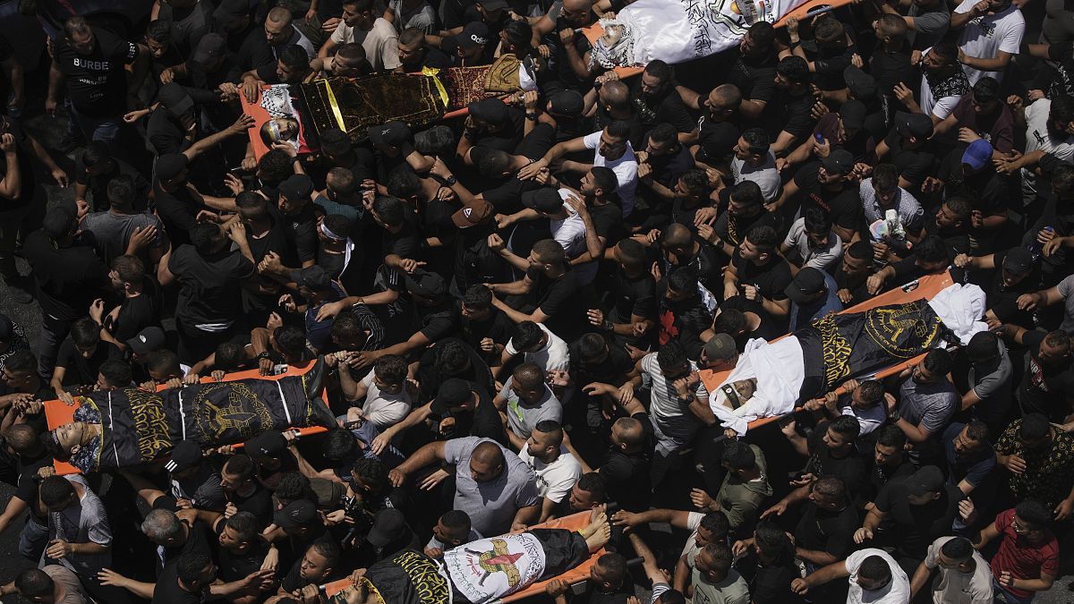 مشيعون يحملون جثمامين فلسطينيين خلال جنازتهم في مخيم جنين بالضفة الغربية المحتلة. 