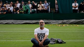 A Just Stop Oil protester sits on Court 18 on day three of the Wimbledon tennis championships in London.