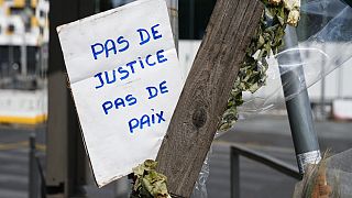 لافتة مكتوب عليها "لا عدالة، لا سلام" من بين رسائل وزهور في مكان مقتل الفتى نائل في بلدة نانتيير غرب باريس، فرنسا.