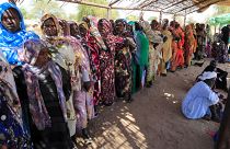 نساء سودانيات ينتظرن في طابور للحصول على المساعدات الإنسانية